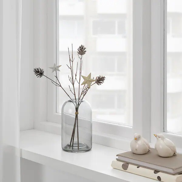 vase en verre avec étoiles et pommes de pin