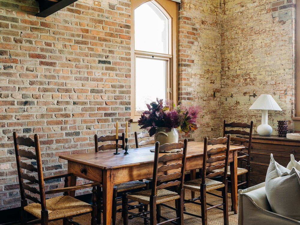 salle à manger avec poutres et briques appartement sous les toits