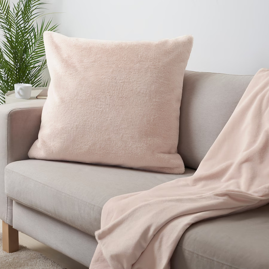 coussin rose sur canapé gris