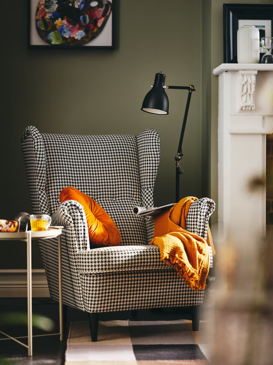 salon avec murs verts et fauteuil pied de poule