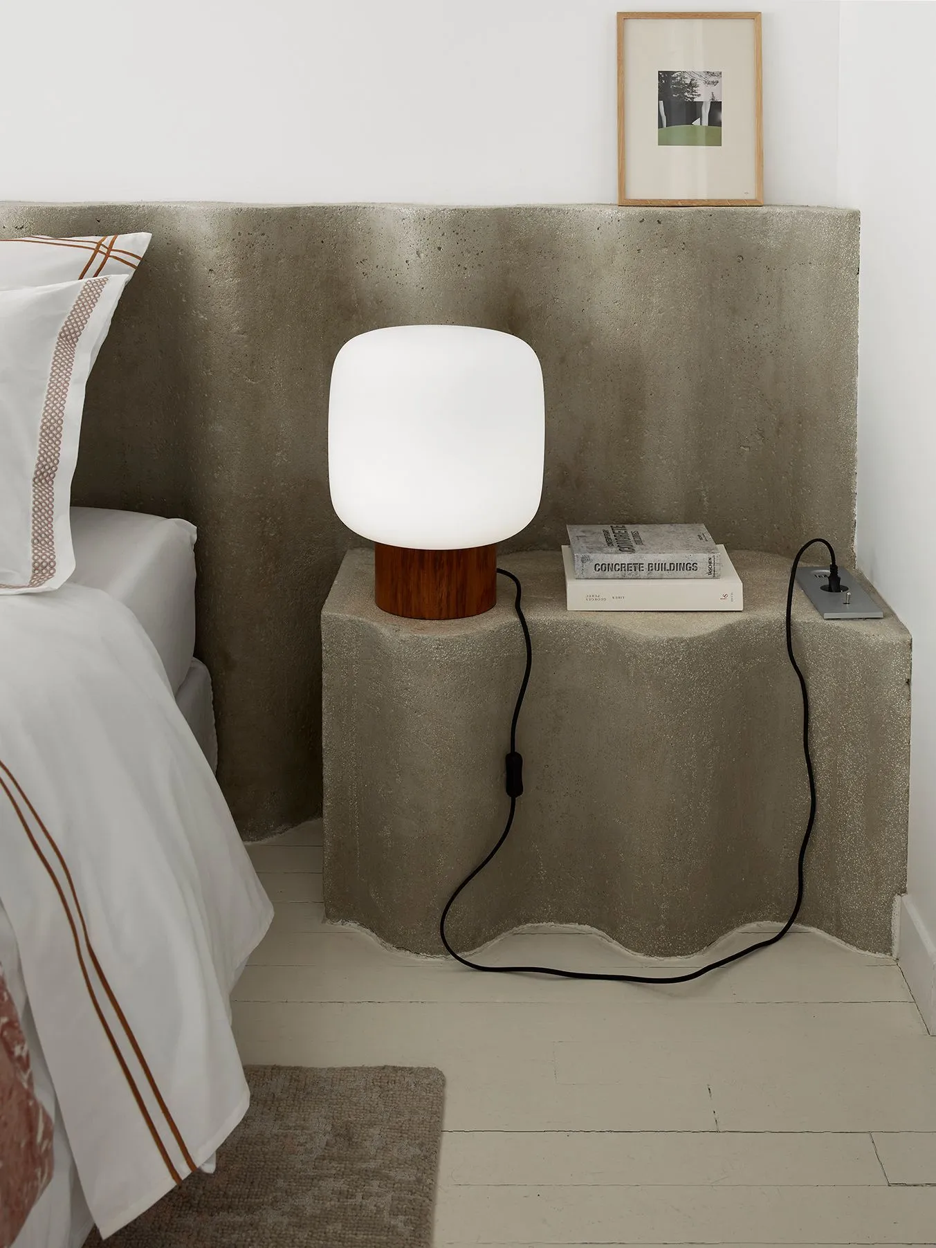 chambre avec tête de lit béton et lampe AM PM
