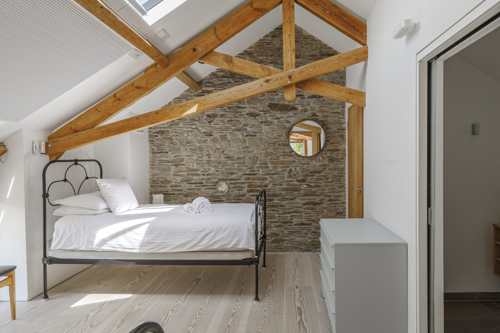 chambre avec poutres et mur de pierres décoration design