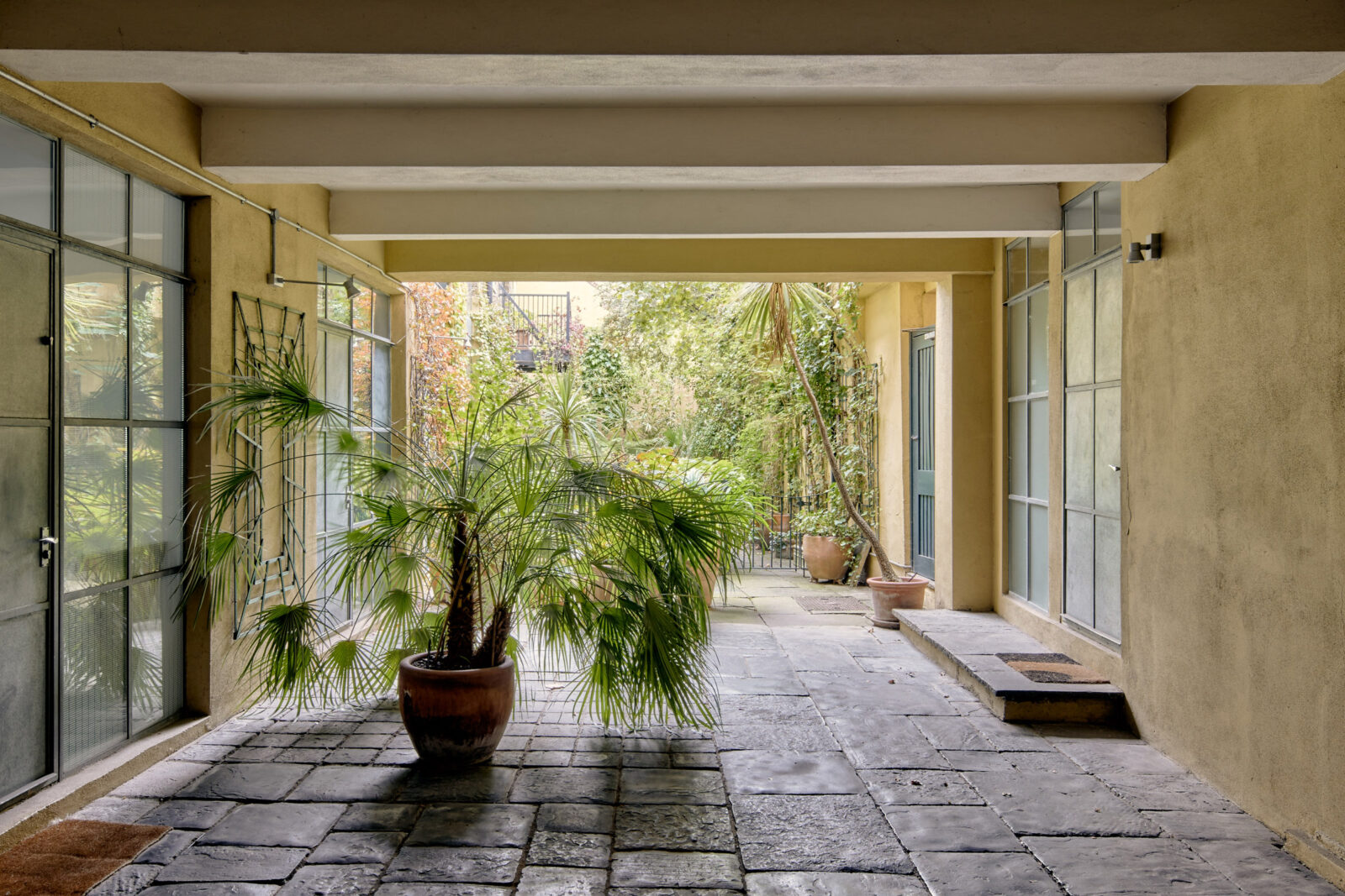 entrée bâtiment sol en pierre sur cour