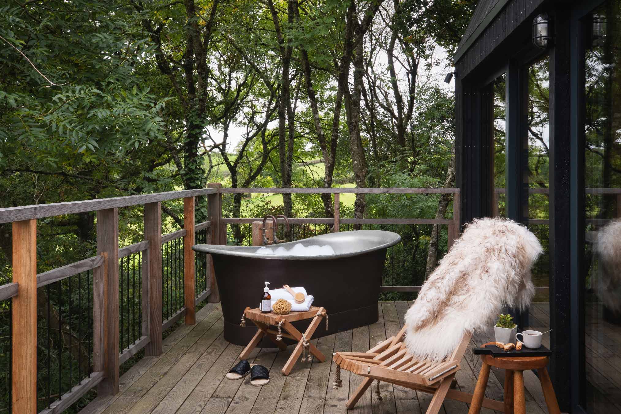 terrasse avec baignoire maison en bois noir dans les arbres terrasse avec baignoire maison en bois noir dans les arbres