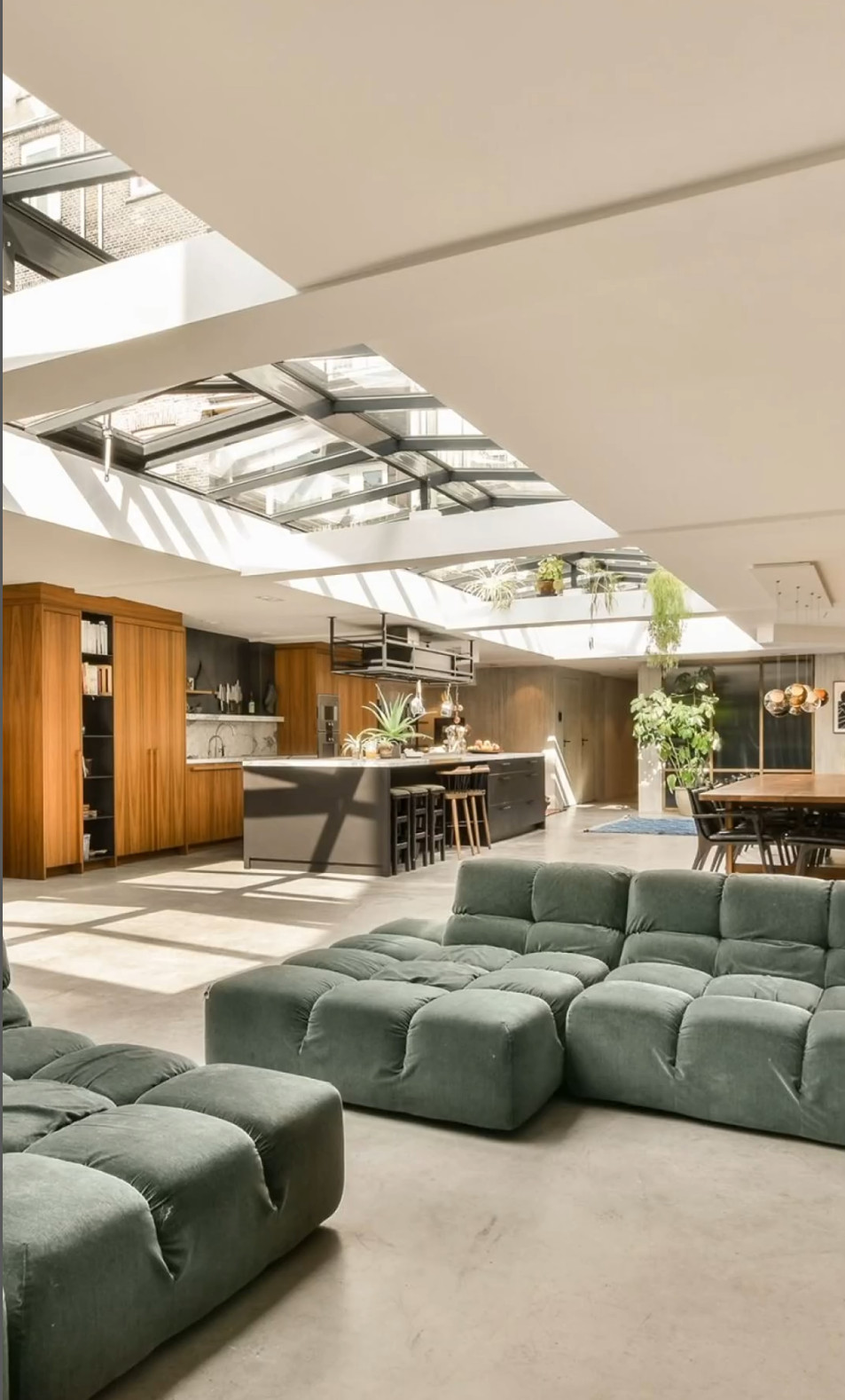 salon canapé vert dans loft avec verrière zénithale