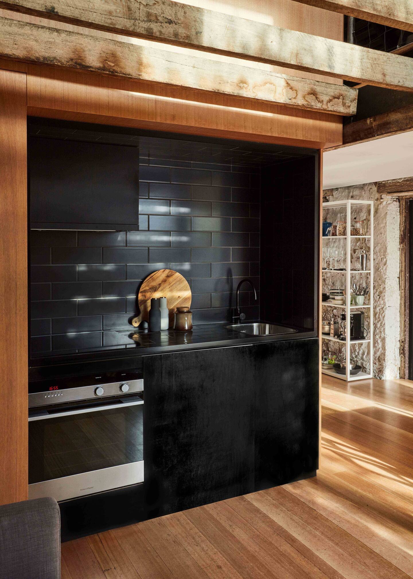 cuisine ouverte design noire avec poutres maison 79m2