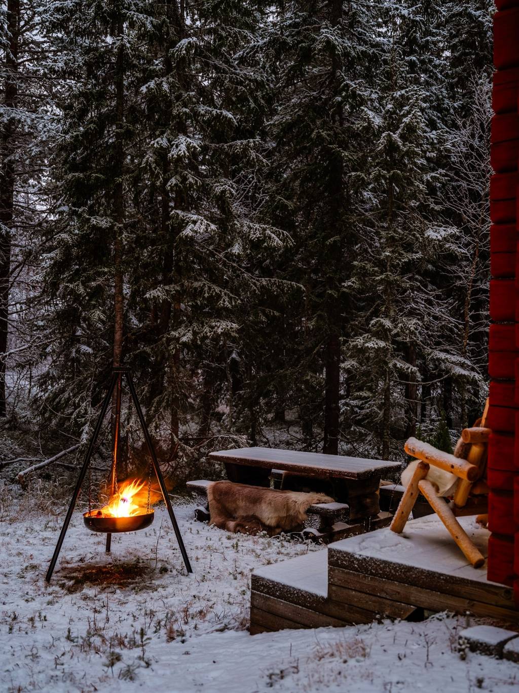 terrasse avec brasero maison en bois rouge dans la neige vue nuit Suède