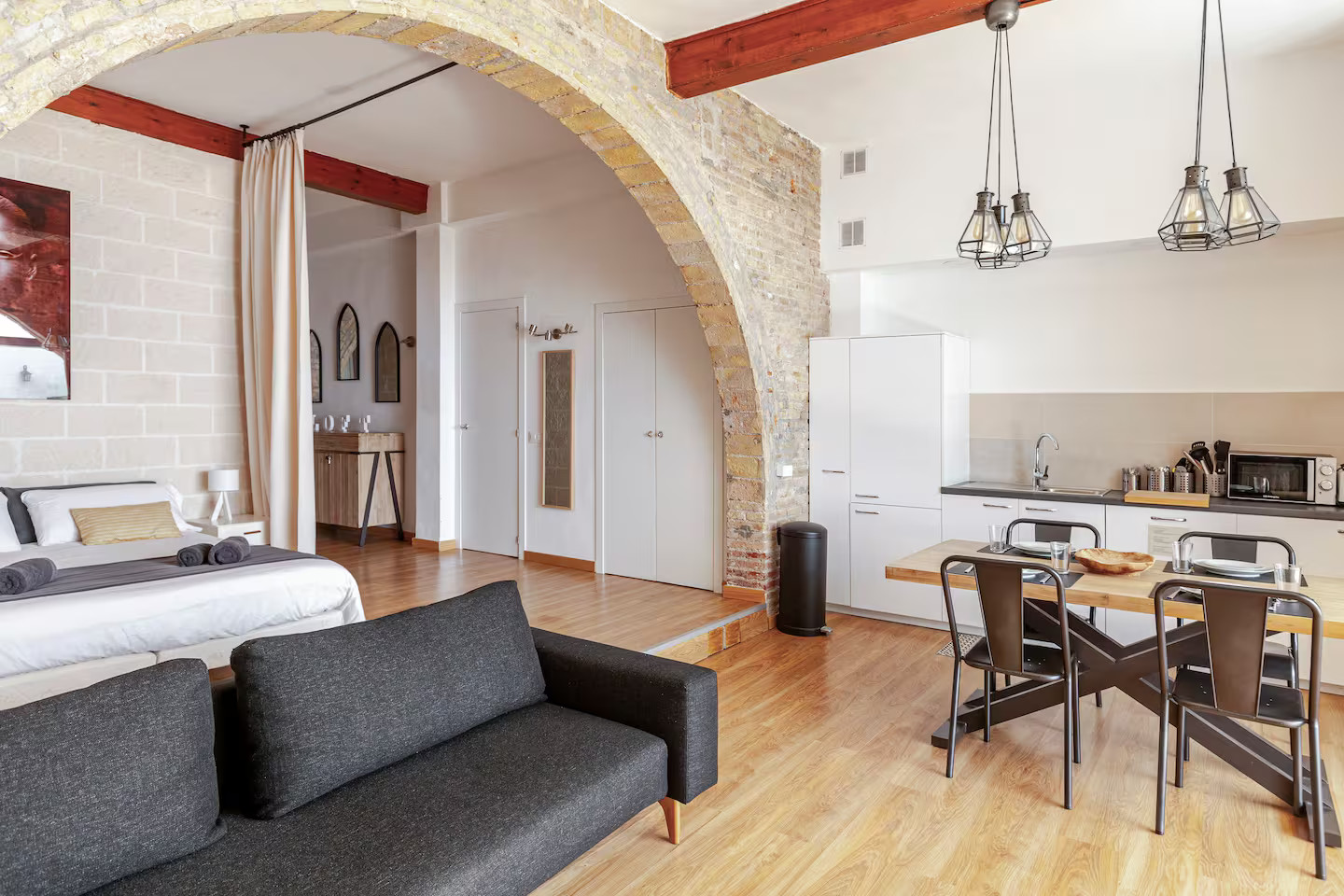 salon et chambre ouverture cintrée appartement Sitges style loft avec briques