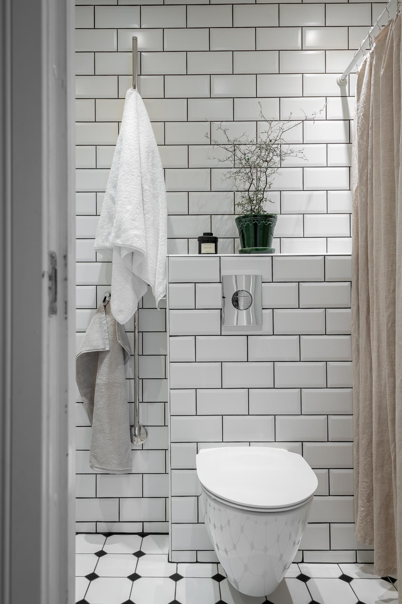 salle de bain blanche carrelage métro sol cabochons noirs