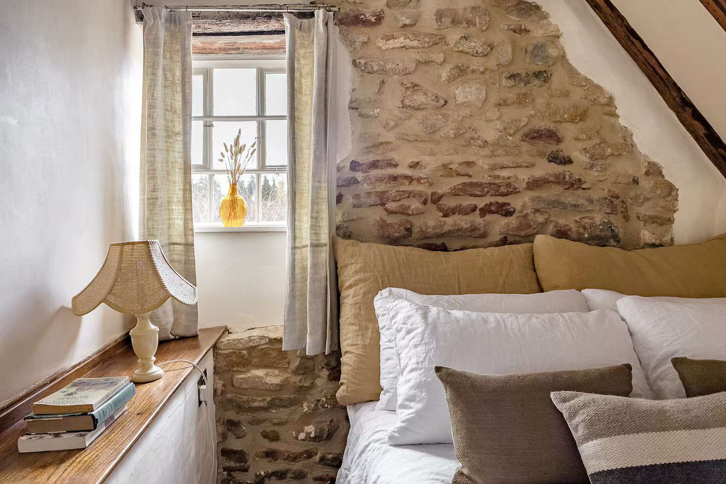 chambre mansardée avec mur de pierres et poutres cottage Cotswolds Angleterre Hoo Cottage