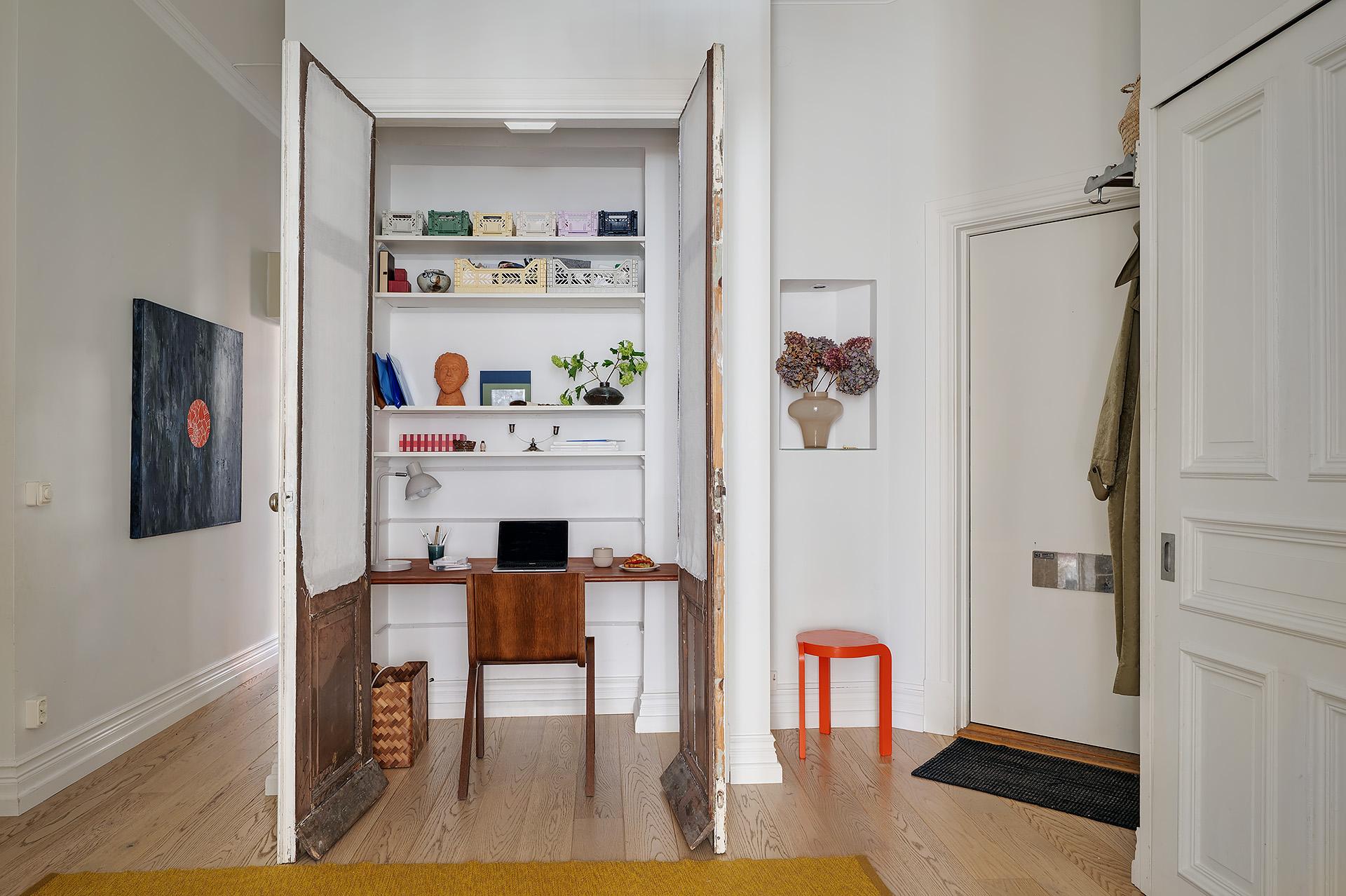 entrée avec bureau dans un placard fermé par portes 