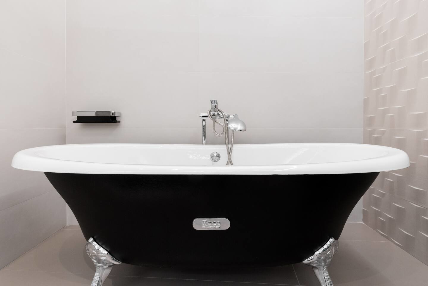 baignoire rétro dans salle de bain blanche et noir marbre