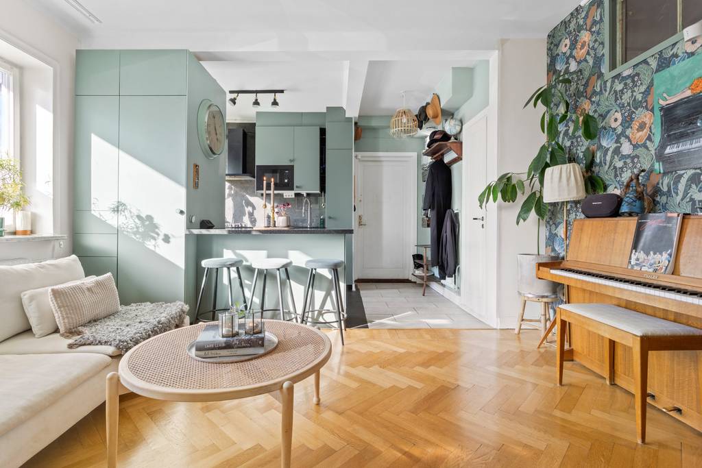 salon avec cuisine ouverte verte et papier-peint appartement 53m2