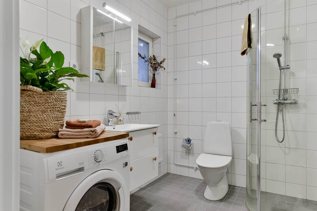 salle de bain blanche avec machine à laver