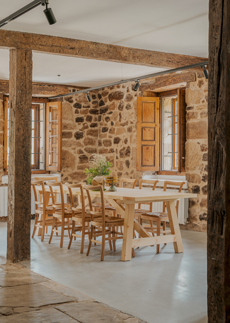 salle à manger avec poutres et murs pierres maison de village rénovée Espagne