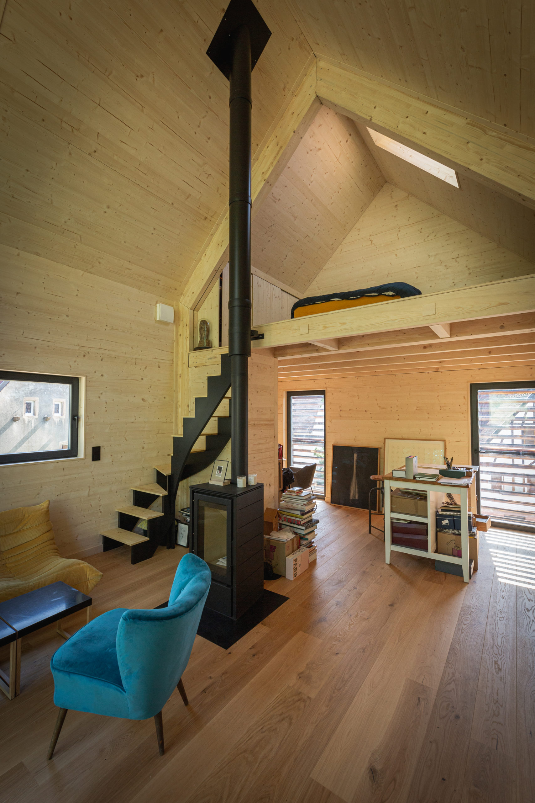 salon avec poêle à bois et mezzanine petite maison 40m2 préfabriquée en Alsace par ÜTE salon avec poêle à bois et mezzanine petite maison 40m2 préfabriquée en Alsace par ÜTE