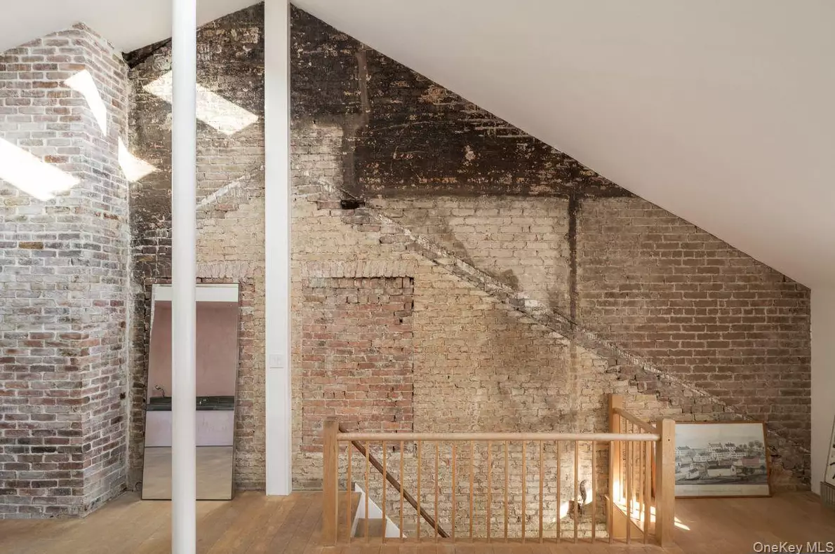 pièce mansardée avec mur de briques anciennes