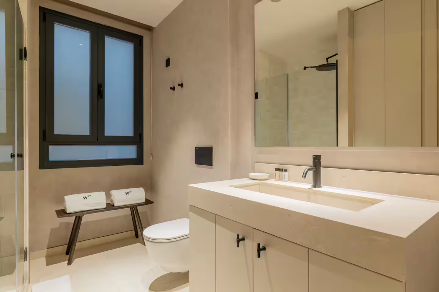 salle de bain contemporaine beige robinetterie noire avec fenêtre