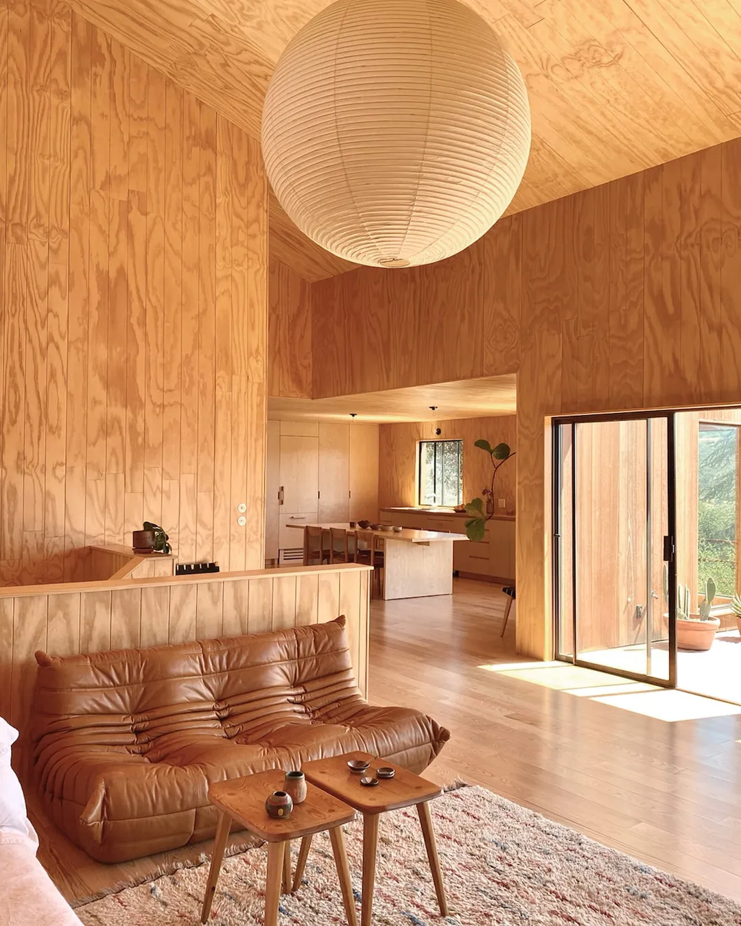 salon avec canapé Togo cuir mur en bois maison en bois Sea Ranch Californie salon avec canapé Togo cuir mur en bois maison en bois Sea Ranch Californie
