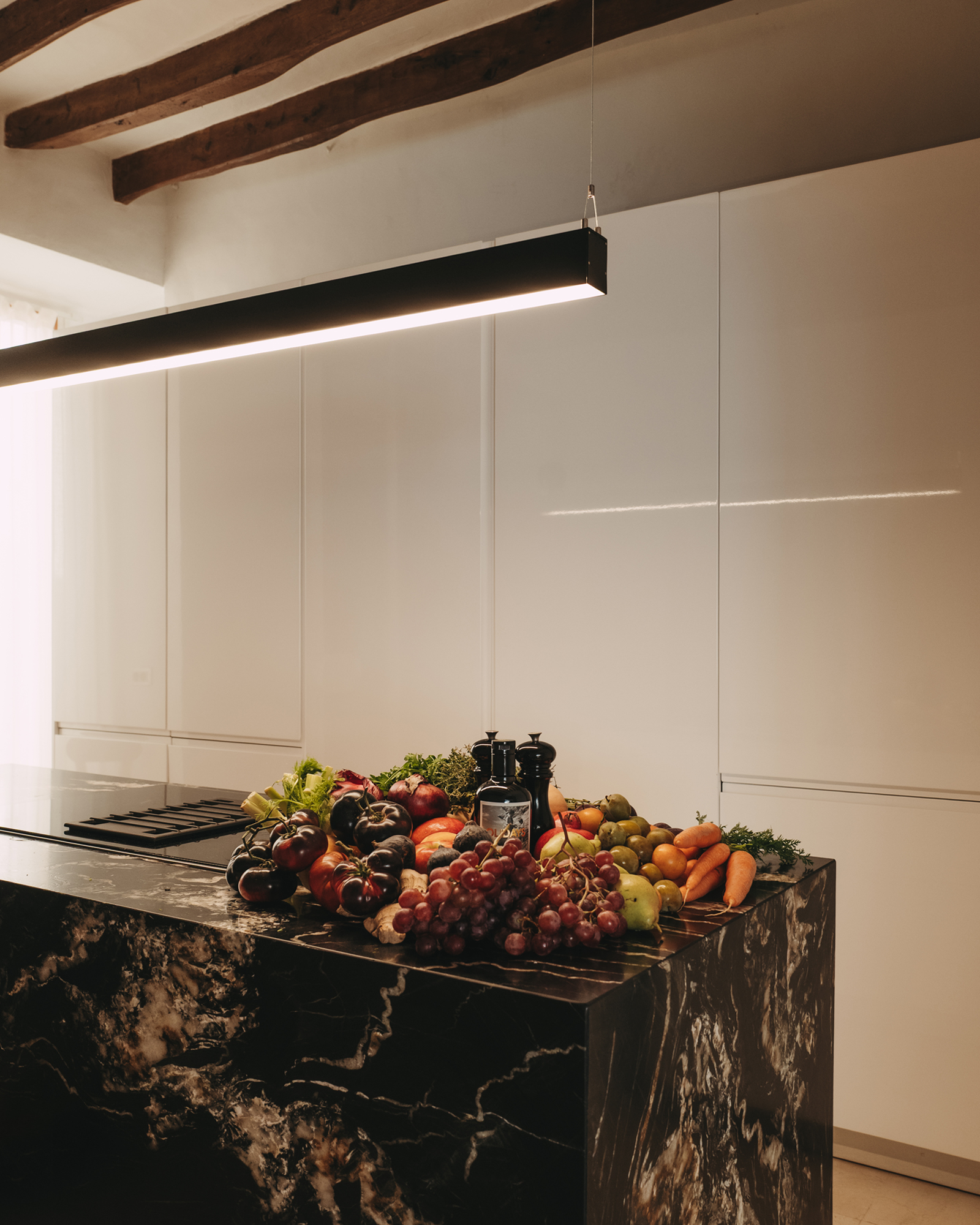 cuisine design blanche avec îlot marbre noir avec poutres décoration contemporaine maison ancienne Majorque cuisine design blanche avec îlot marbre noir avec poutres décoration contemporaine maison ancienne Majorque