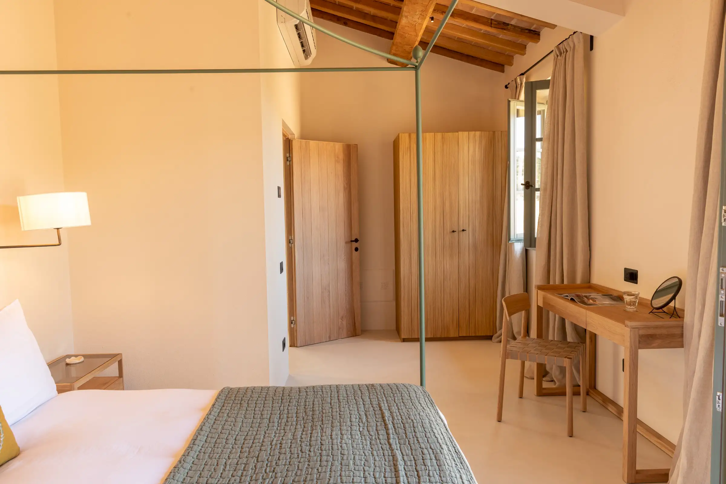 chambre avec lit baldaquin métal vert et poutres maison en pierres ancienne rénovée Podere Sirolo Italie chambre avec lit baldaquin métal vert et poutres maison en pierres ancienne rénovée Podere Sirolo Italie
