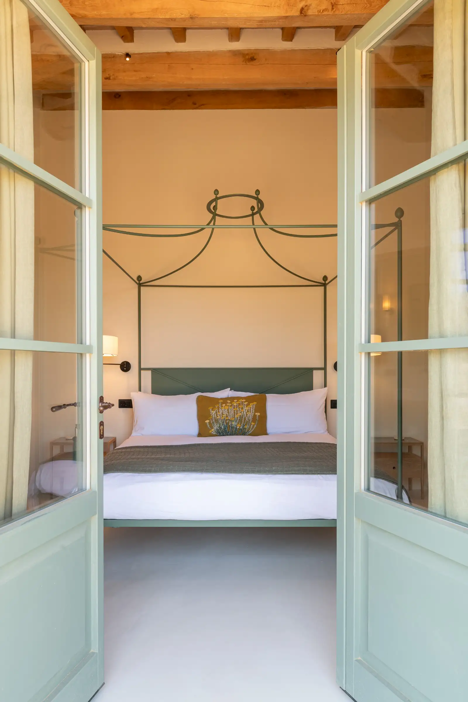 chambre avec lit baldaquin métal vert et poutres maison en pierres ancienne rénovée Podere Sirolo Italie chambre avec lit baldaquin métal vert et poutres maison en pierres ancienne rénovée Podere Sirolo Italie
