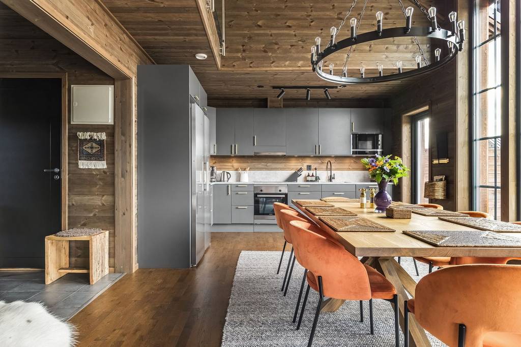 salle à manger chaise velours orange et cuisine design grise dans maison en bois chalet de montagne salle à manger chaise velours orange et cuisine design grise dans maison en bois chalet de montagne