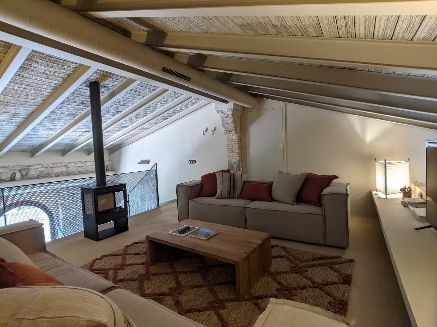 salon avec poêle sur mezzanine maison en pierres ancienne rénovée décoration contemporaine