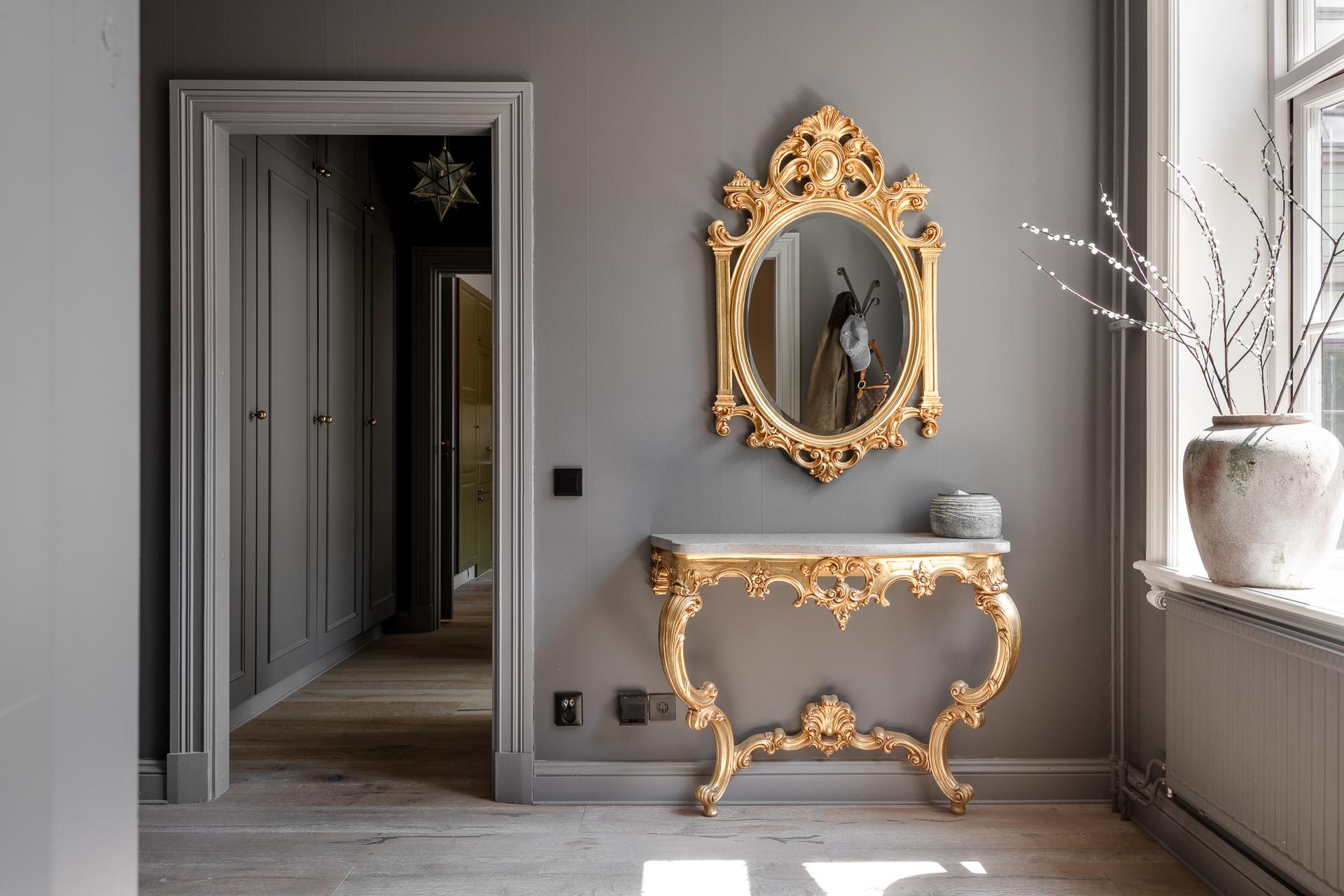 entrée murs gris avec miroir et console baroque dorés deux-pièces 66m2 entrée murs gris avec miroir et console baroque dorés deux-pièces 66m2