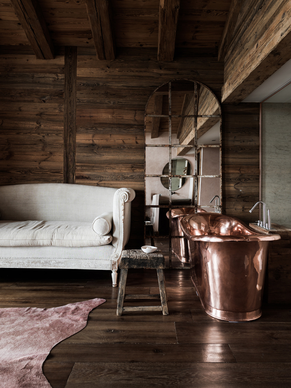 salle de bain avec baignoire cuivre à l'ancienne chalet familial en Suisse décoration contemporaine beige et bois
