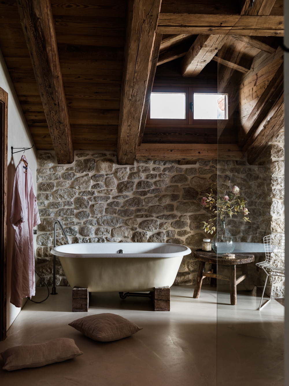 salle de bain murs pierres et poutres chalet familial en Suisse décoration contemporaine beige et bois