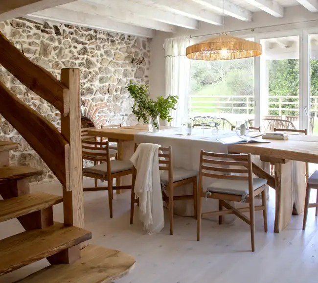 salle à manger avec poutres et escalier maison en pierres décoration rustique chic