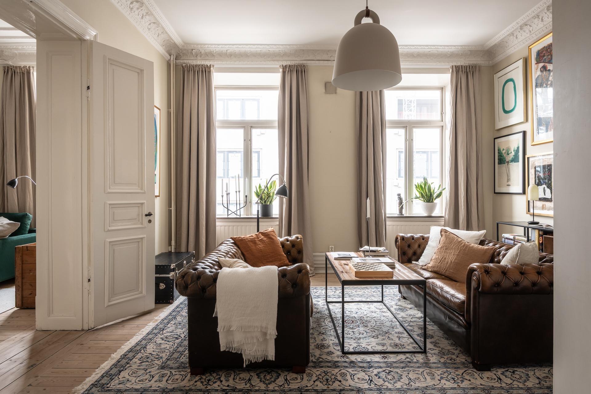 salon avec canapé Chesterfield cuir marron moulures appartement type haussmannien décoration classique chic salon avec canapé Chesterfield cuir marron moulures appartement type haussmannien décoration classique chic