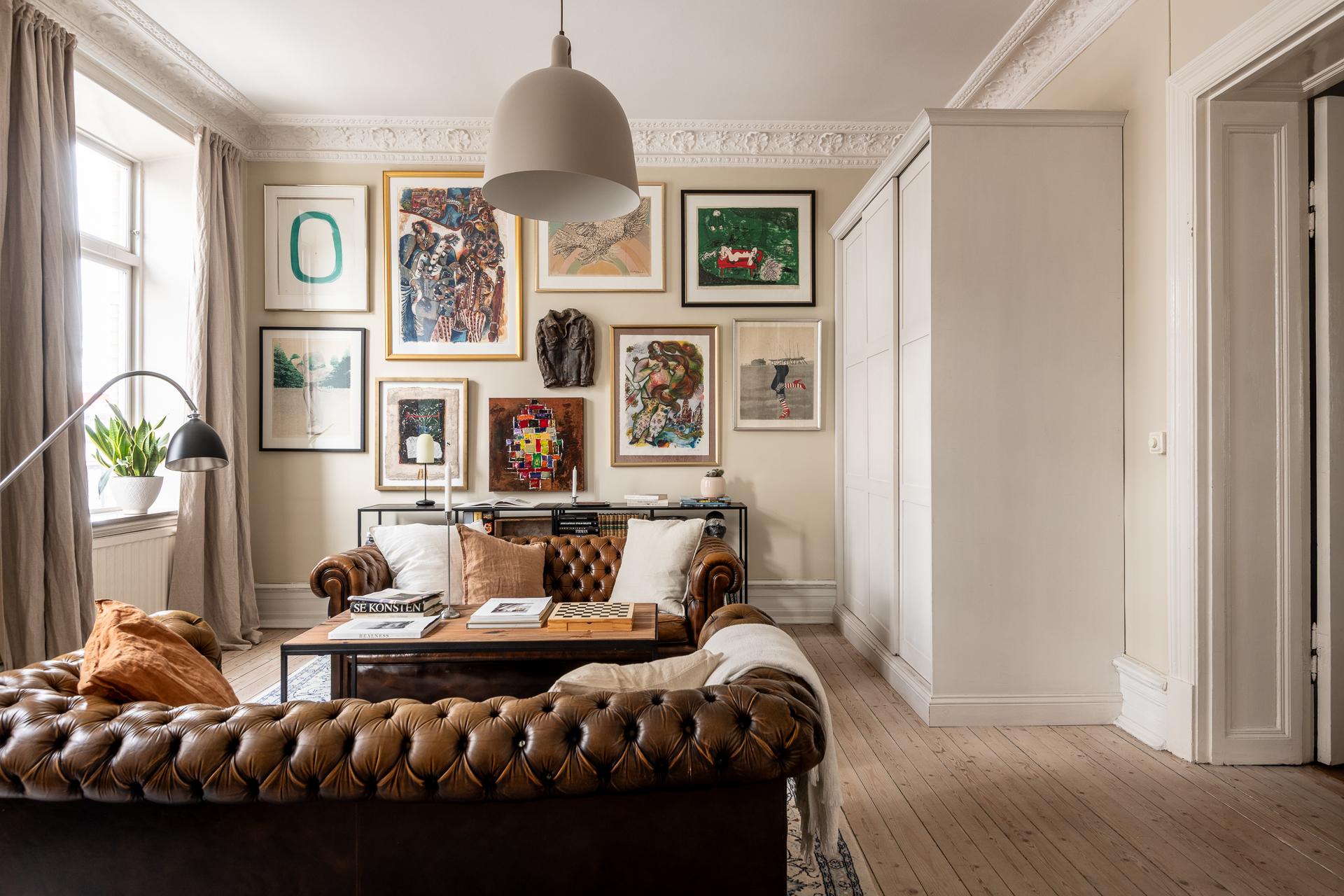 salon avec canapé Chesterfield cuir marron moulures appartement type haussmannien décoration classique chic salon avec canapé Chesterfield cuir marron moulures appartement type haussmannien décoration classique chic