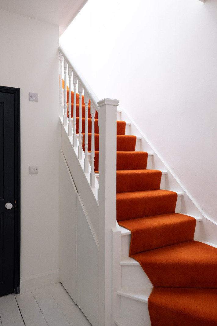 escalier bois peint en blanc et tapis d'escalier rouge