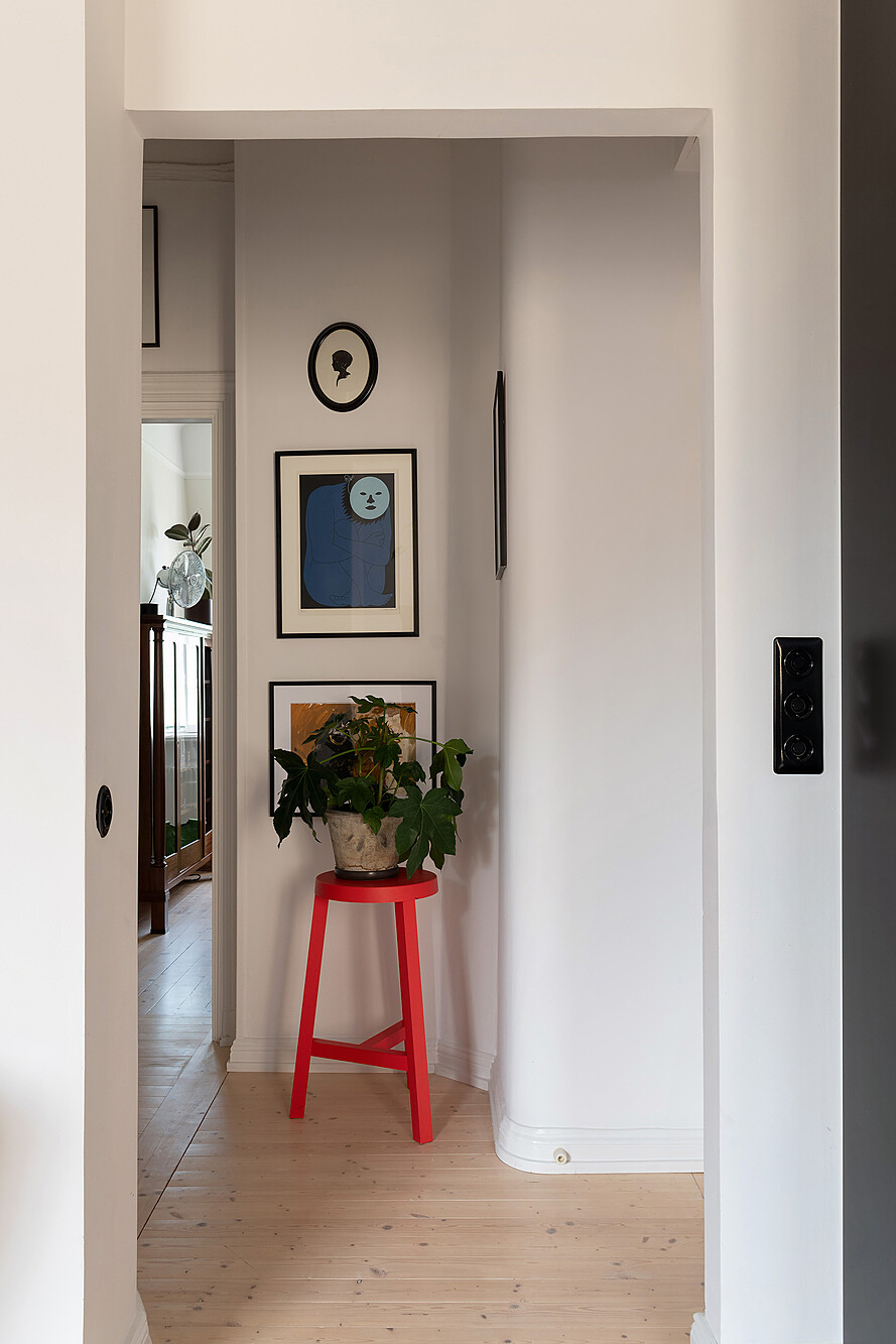couloir avec porte-plantes rouge