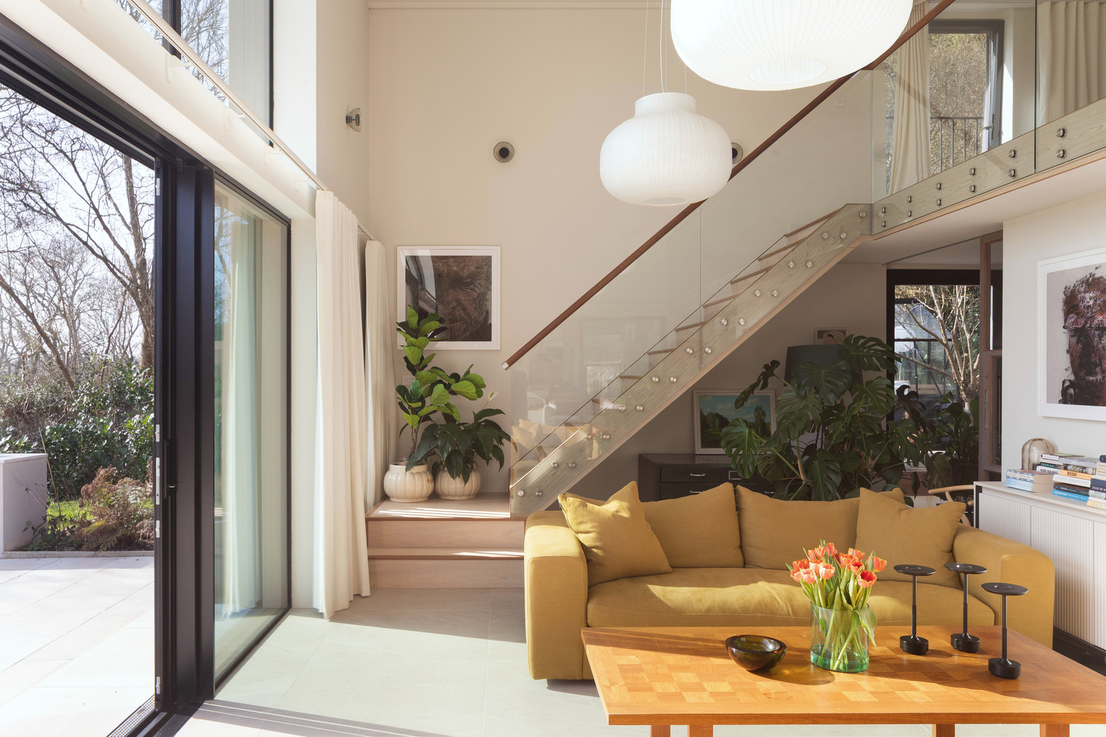 salon double hauteur avec escalier maison contemporaine durable avec grandes baies vitrées et jardin paysagé salon double hauteur avec escalier maison contemporaine durable avec grandes baies vitrées et jardin paysagé