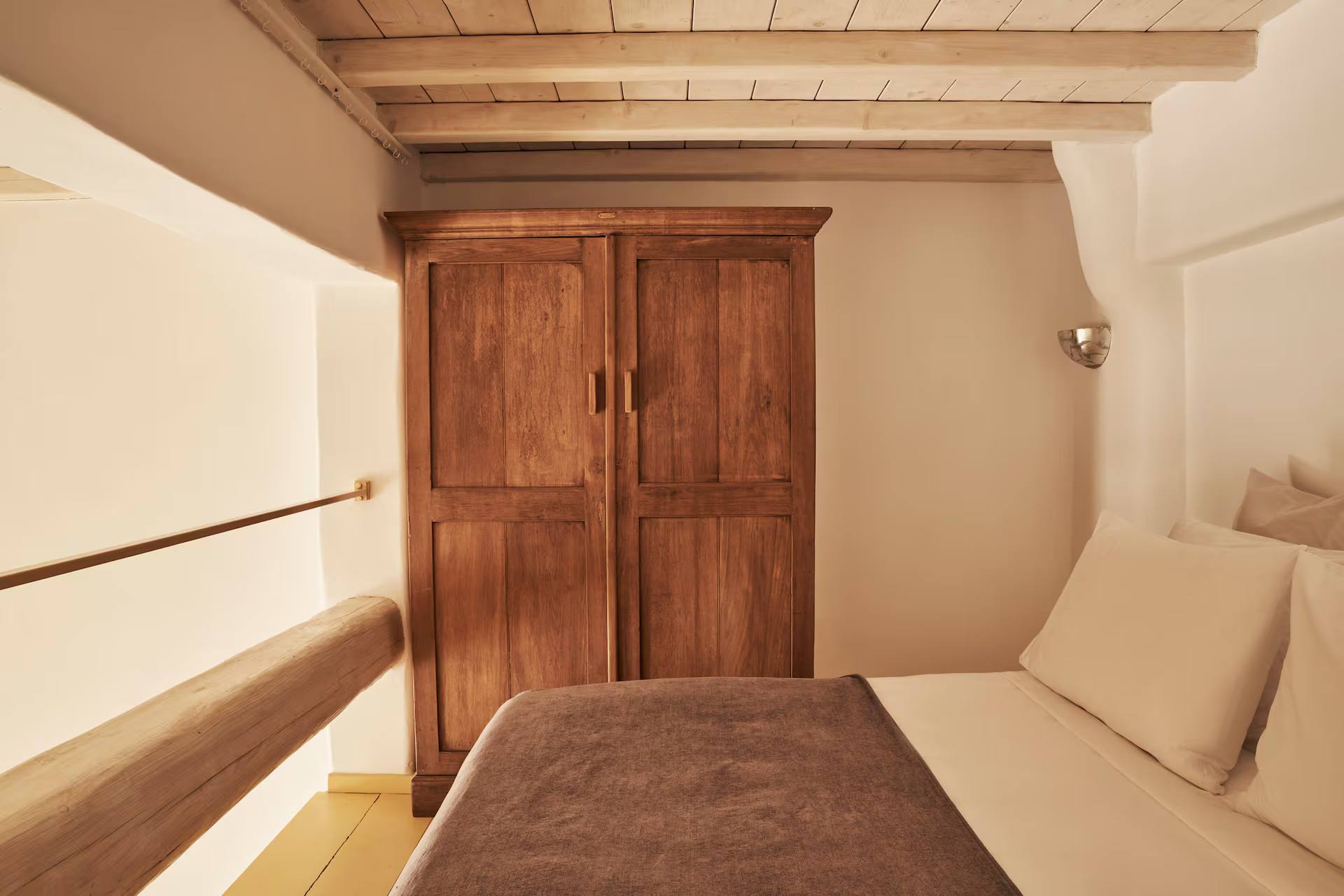chambre sur mezzanine avec poutres décoration rustique maison de ville Mykonos