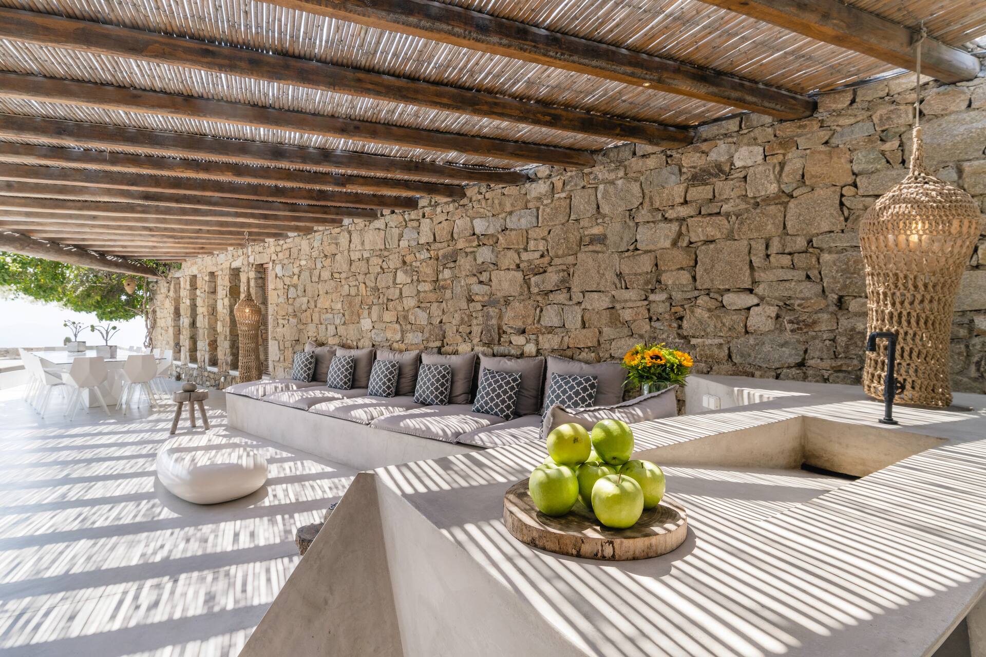 terrasse mur de pierre avec cuisine d'été et pergola