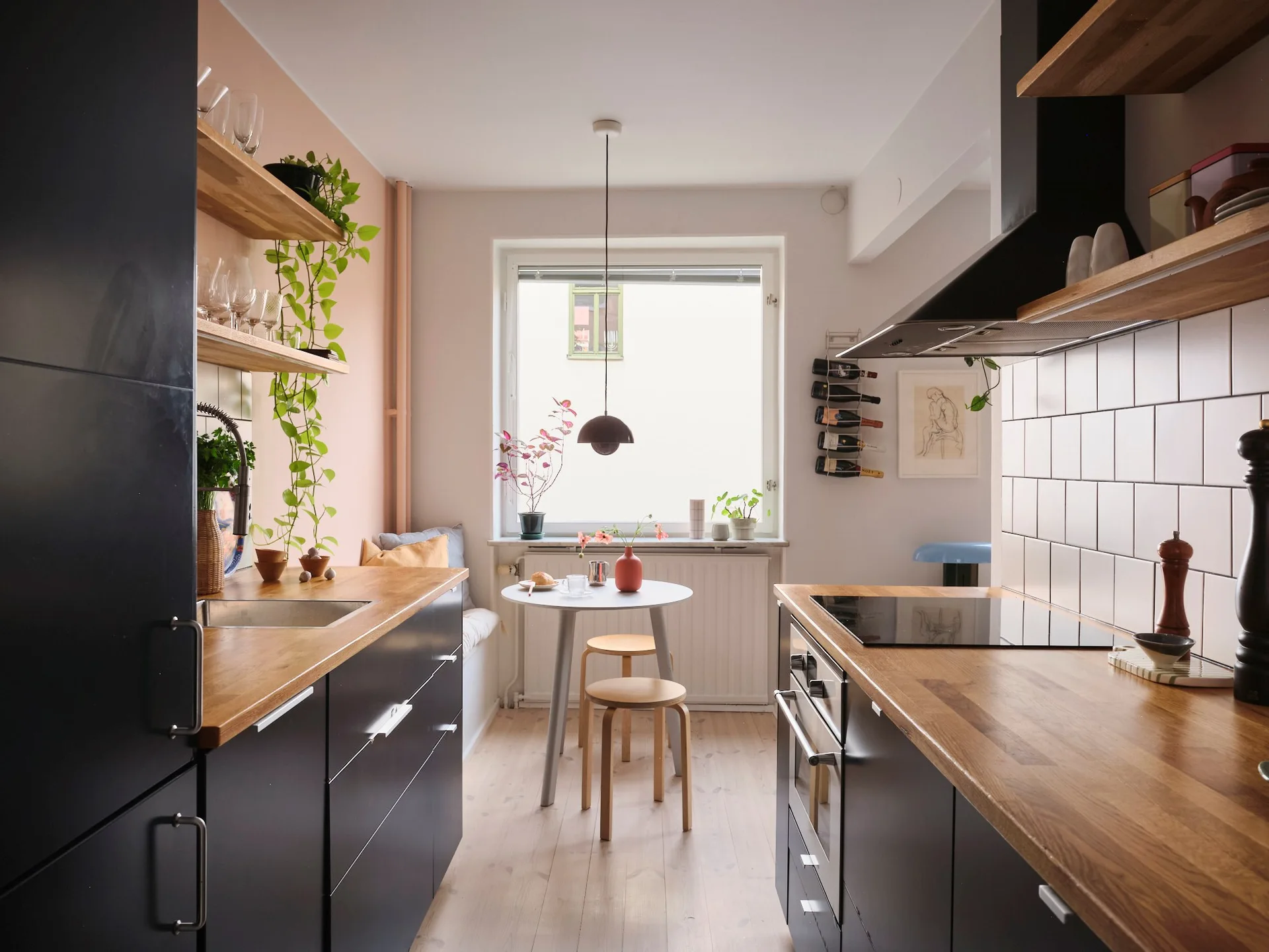 Semi-open blue kitchen with pink wall, dining area with bench colourful 54m2 Scandinavian-style flat