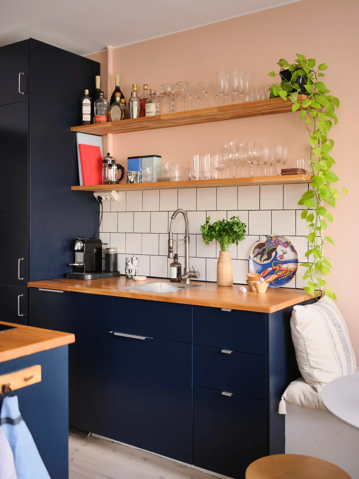 Semi-open blue kitchen with pink wall, dining area with bench colourful 54m2 Scandinavian-style flat
