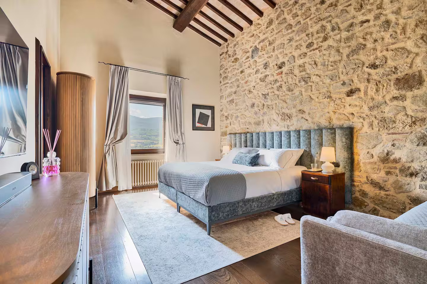 chambre avec poutres et mur pierres maison en pierres Toscane Italie