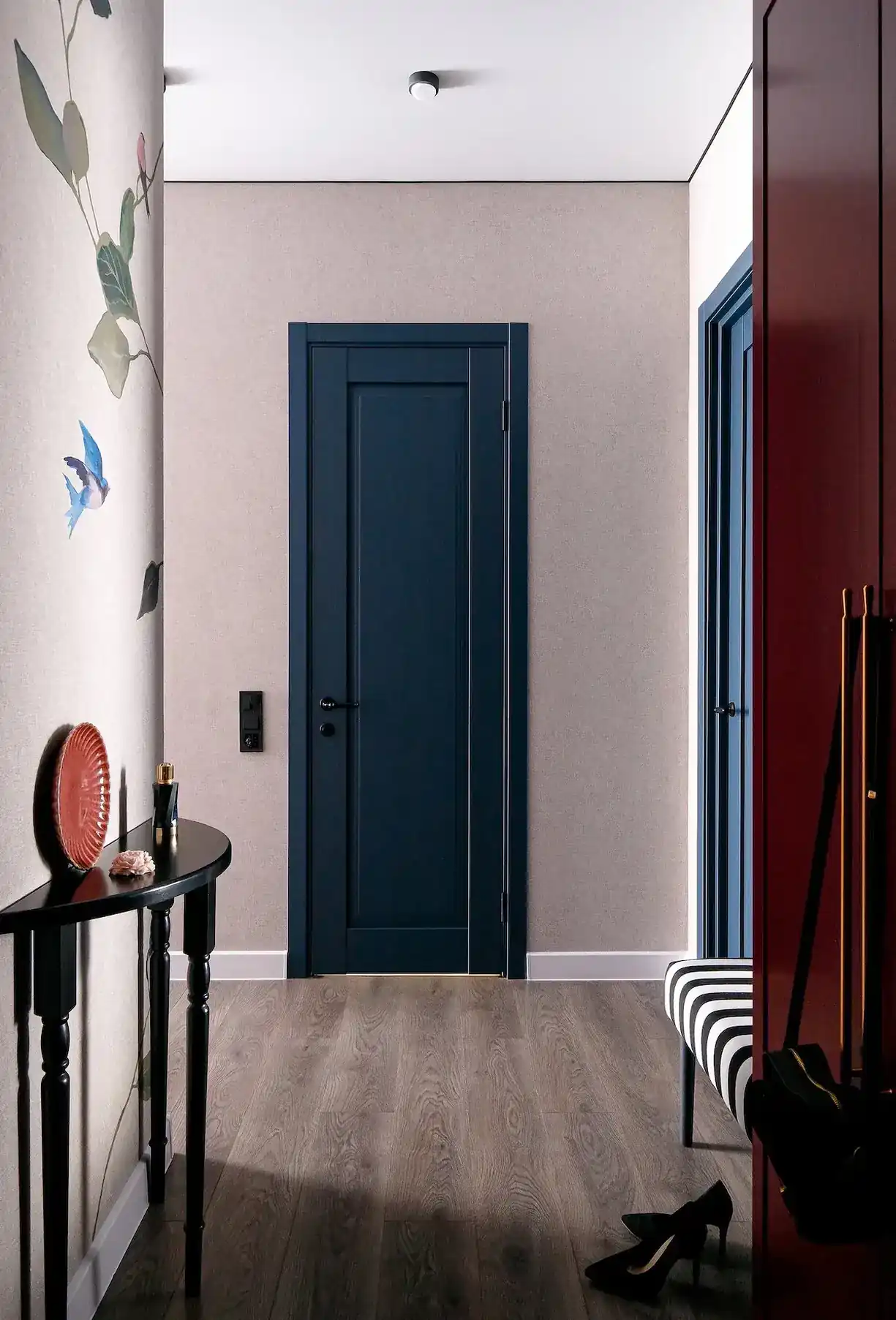 entrée banc rayé placard rouge appartement de 45m2 décoration maximaliste et colorée