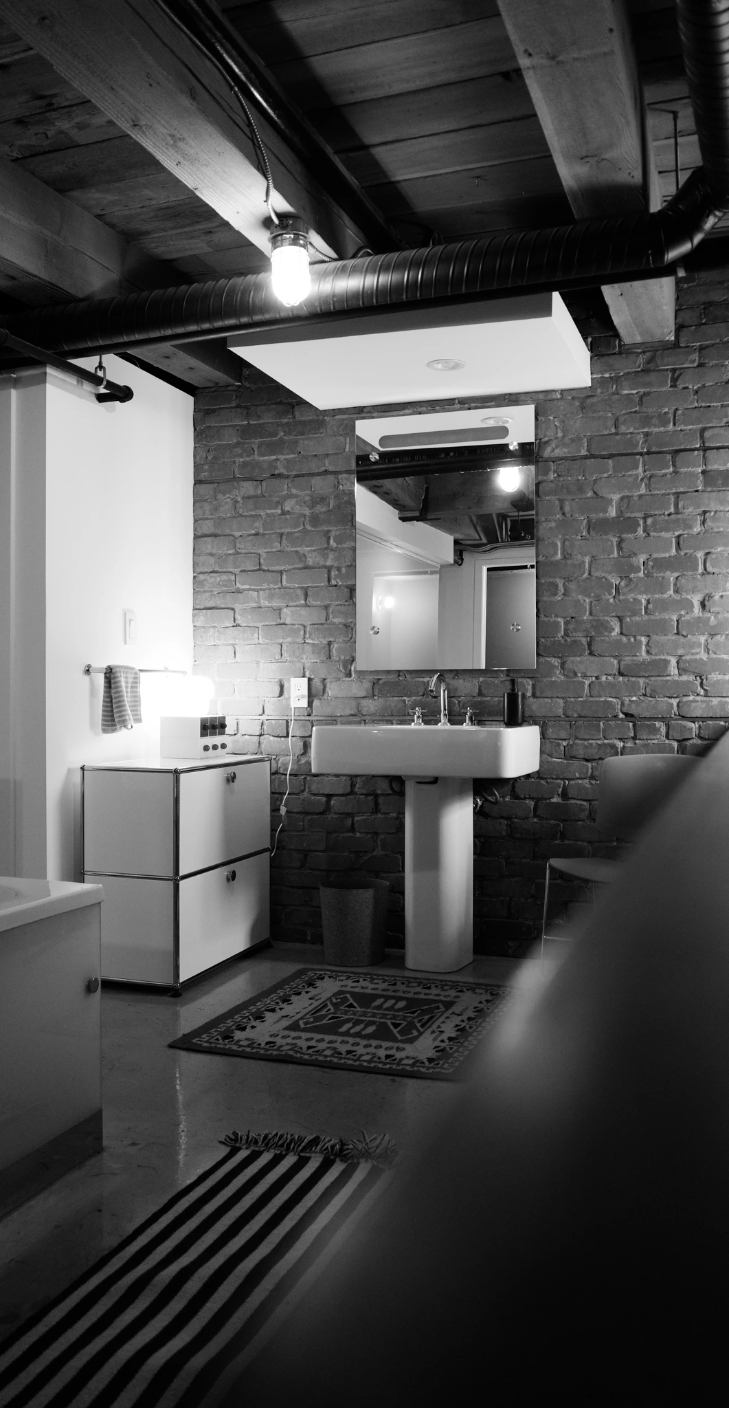 salle de bain sol béton appartement ancien à Vancouver type loft avec mur de briques anciennes décoration vintage salle de bain sol béton appartement ancien à Vancouver type loft avec mur de briques anciennes décoration vintage