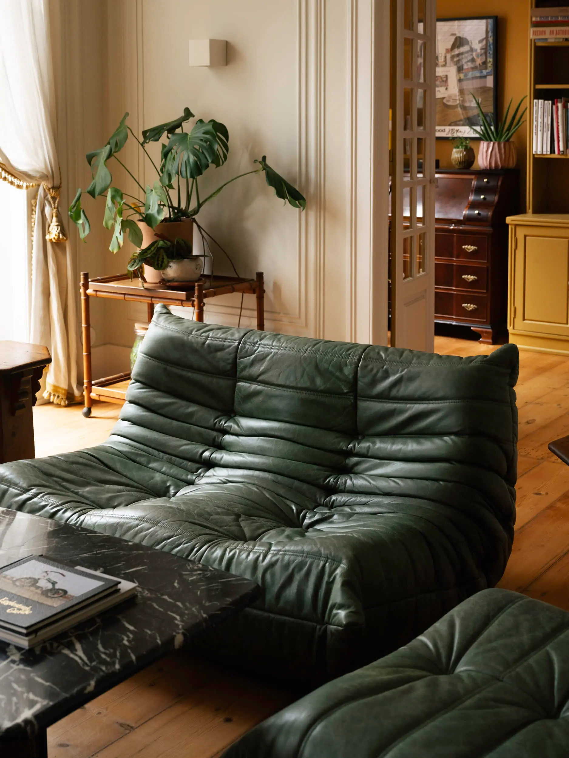 living room with green leather Togo sofa vintage apartment in Lisbon with refreshing garden living room with green leather Togo sofa vintage apartment in Lisbon with refreshing garden