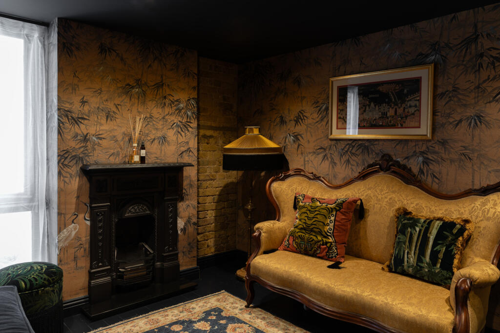 petit salon avec cheminée ancienne en fonte canapé rococo jaune décoration vintage appartement en duplex Londres petit salon avec cheminée ancienne en fonte canapé rococo jaune décoration vintage appartement en duplex Londres