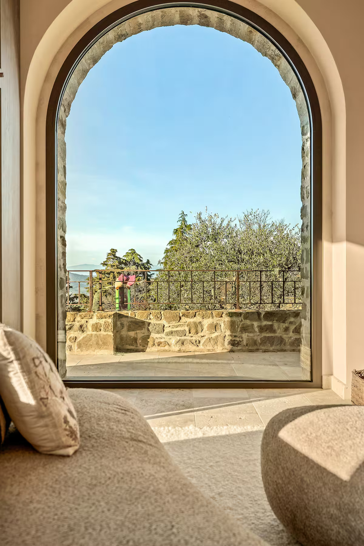 living room with arched window stone house with pool La Torre Umbria