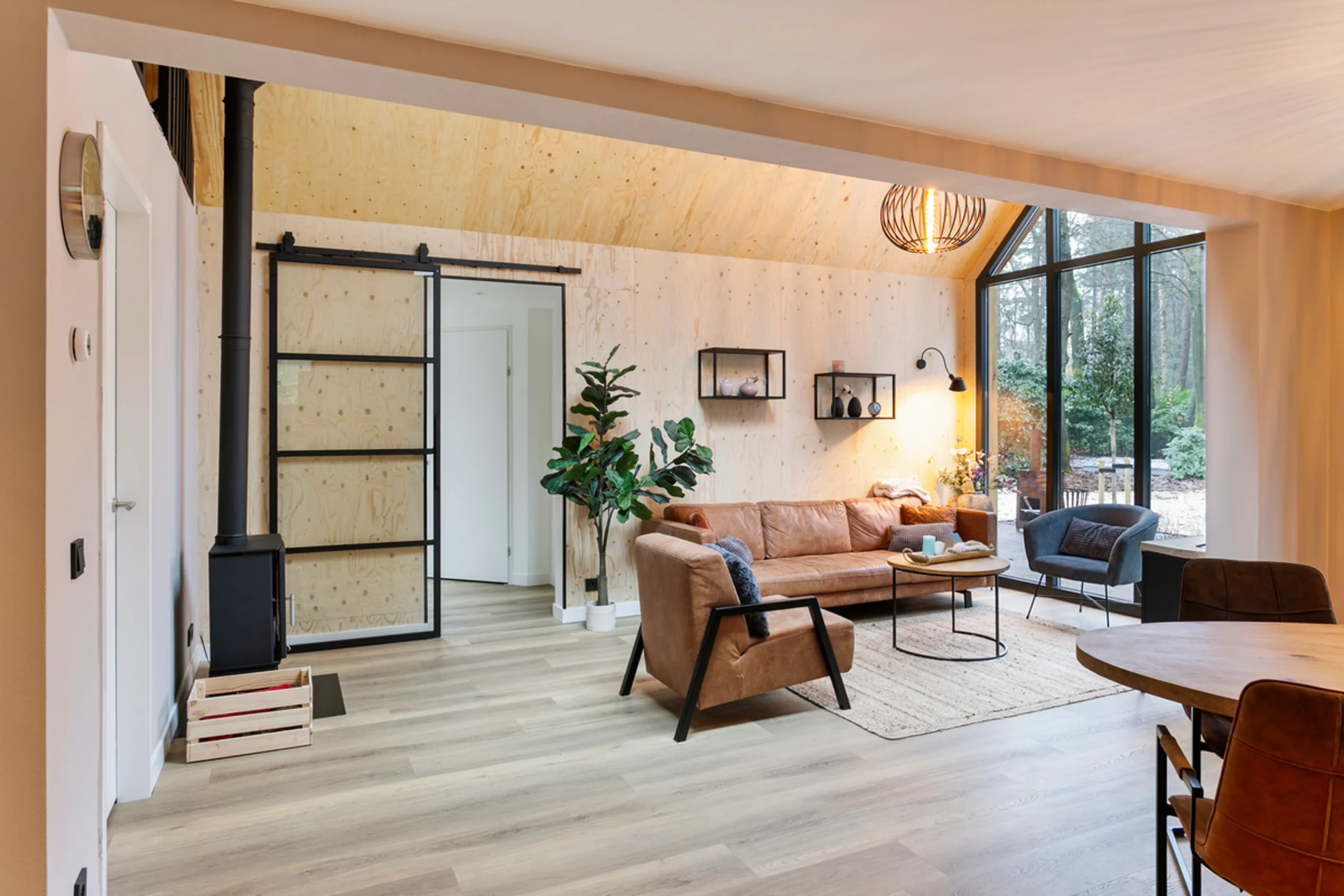 living room with double-height glass gable modern wooden house with lush garden Netherlands living room with double-height glass gable modern wooden house with lush garden Netherlands