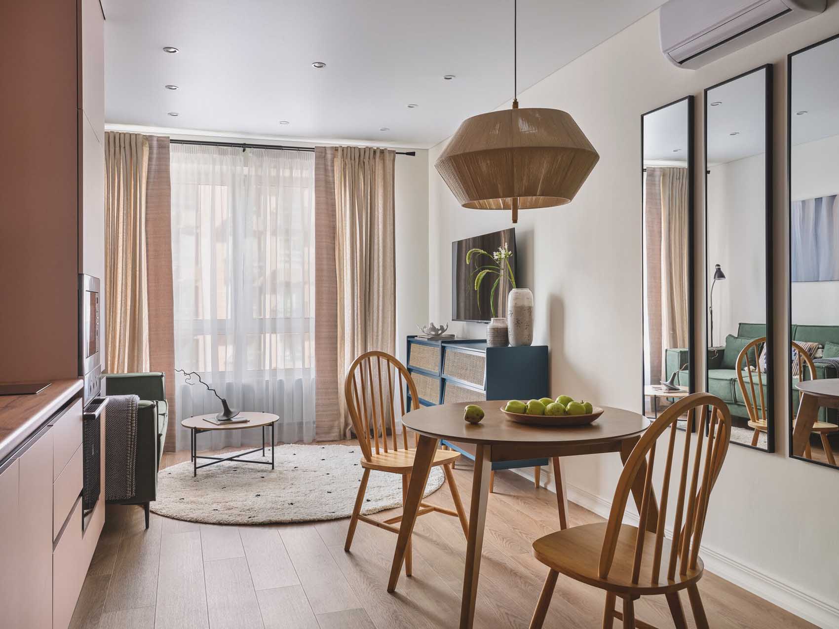 pink kitchen dining room and living room with green sofa in a two-room 42sqm apartment