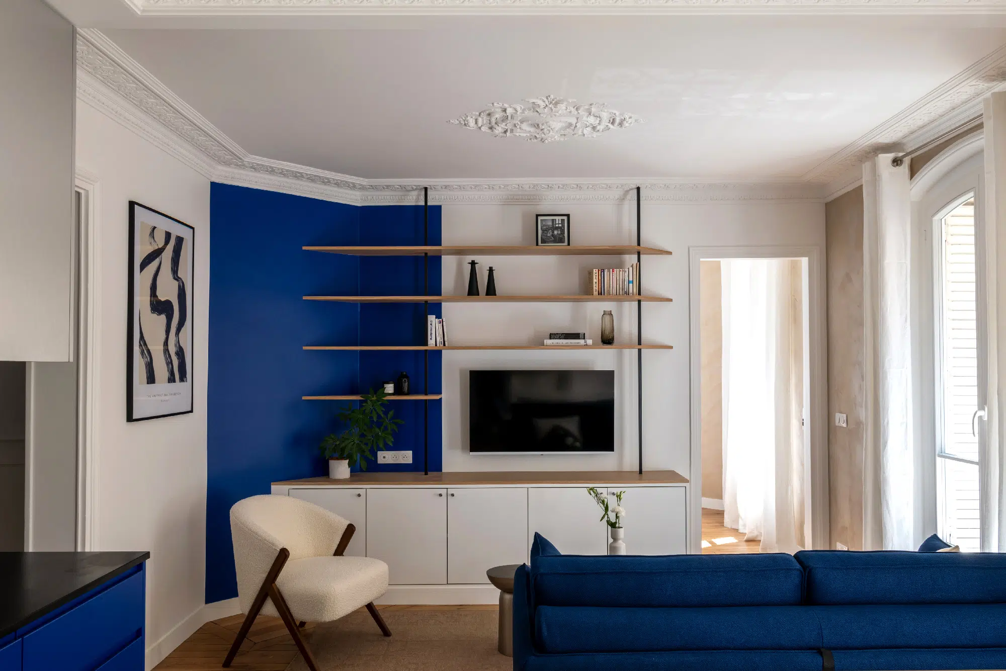 salon avec moulures et cuisine appartement haussmannien de 46m2 rénové en bleu Klein Photo : ©Agathe Tissier salon avec moulures et cuisine appartement haussmannien de 46m2 rénové en bleu Klein Photo : ©Agathe Tissier